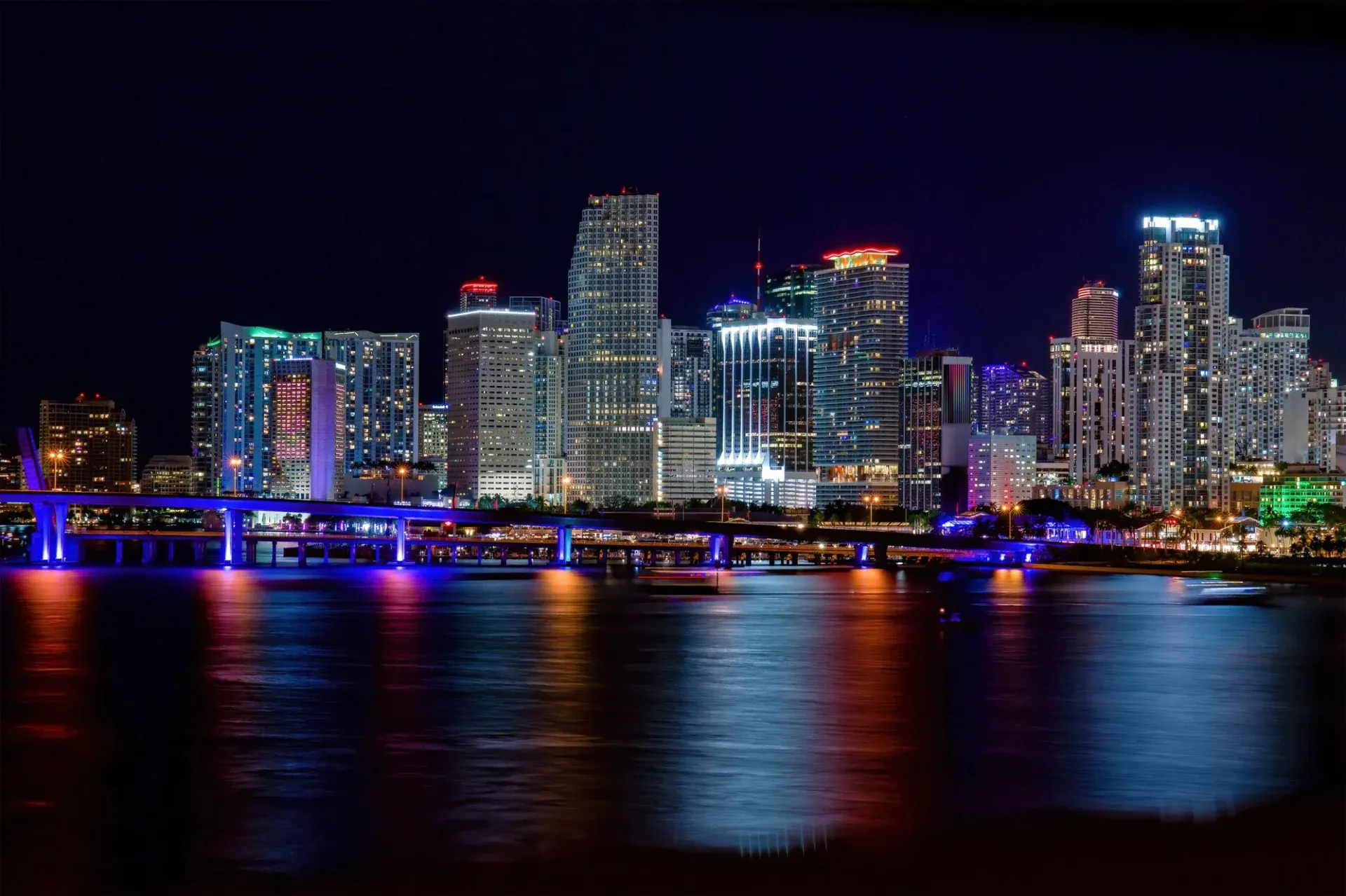 Miami skyline lit up at night across Biscayne Bay